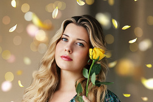 Beautiful woman holding a yellow rose, petals falling and golden, a Person Photo by Studio ANNA