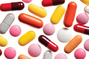 Colorful pills and capsules scattered on white background, repre, a Photo by Studio ANNA