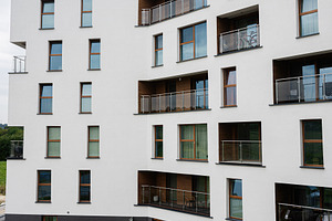 Modern apartment building with balconies  on a cloudy day, a Photo by AS photostudio