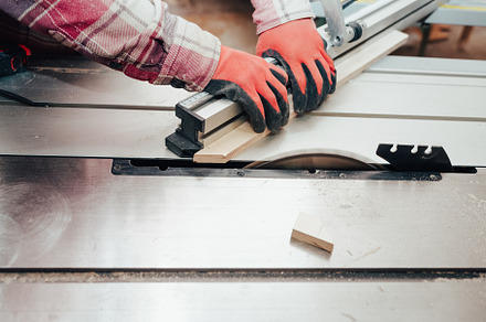 Carpenter cuts plywood on a circular, a Photo by borodai94