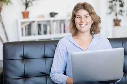 Smiling woman sitting on a sofa at h stock photo containing adult and