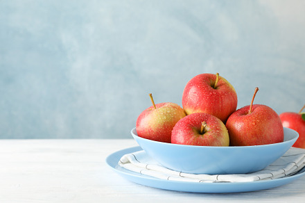 Composition with plate and apples on white wooden background, co, a Food & Drink Photo by AtlasStudio