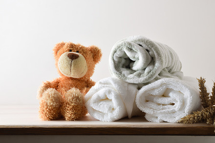 Towels and bathrobe on cabinet with teddy white isolated backgro, a Health & Medical Photo by Davizro's Market