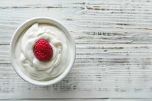 Bowl with white yogurt and ripe raspberry on wooden table, a Food & Drink Photo by AlyaAnd