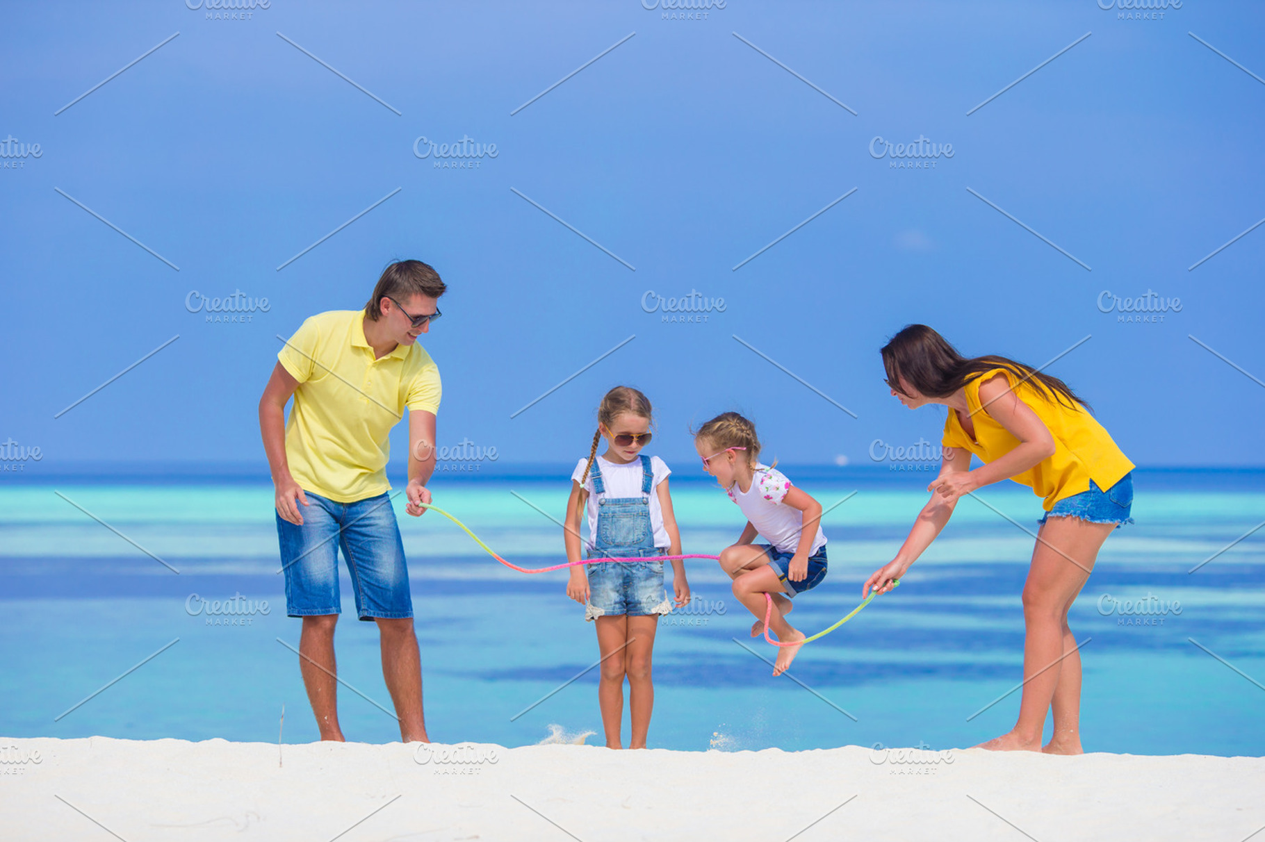 Happy family playing together on white beach featuring adult, beach, and child, a Person Photo by travnikovstudio