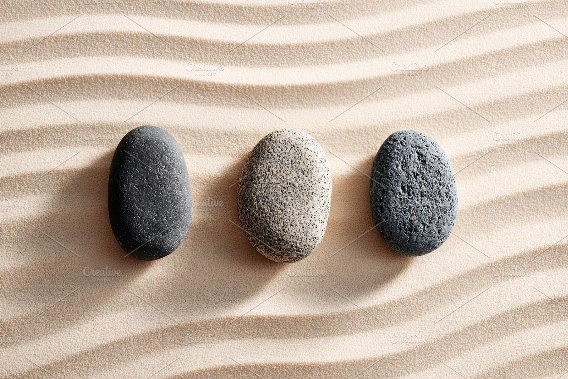 Three smooth stones on sandy surface, a Beauty & Fashion Photo by AlyaAnd