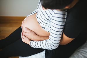 Pregnant couple hugging and touching