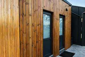 Wooden building WC facade with glass doors and modern design under daylight, a Photo by AS photostudio