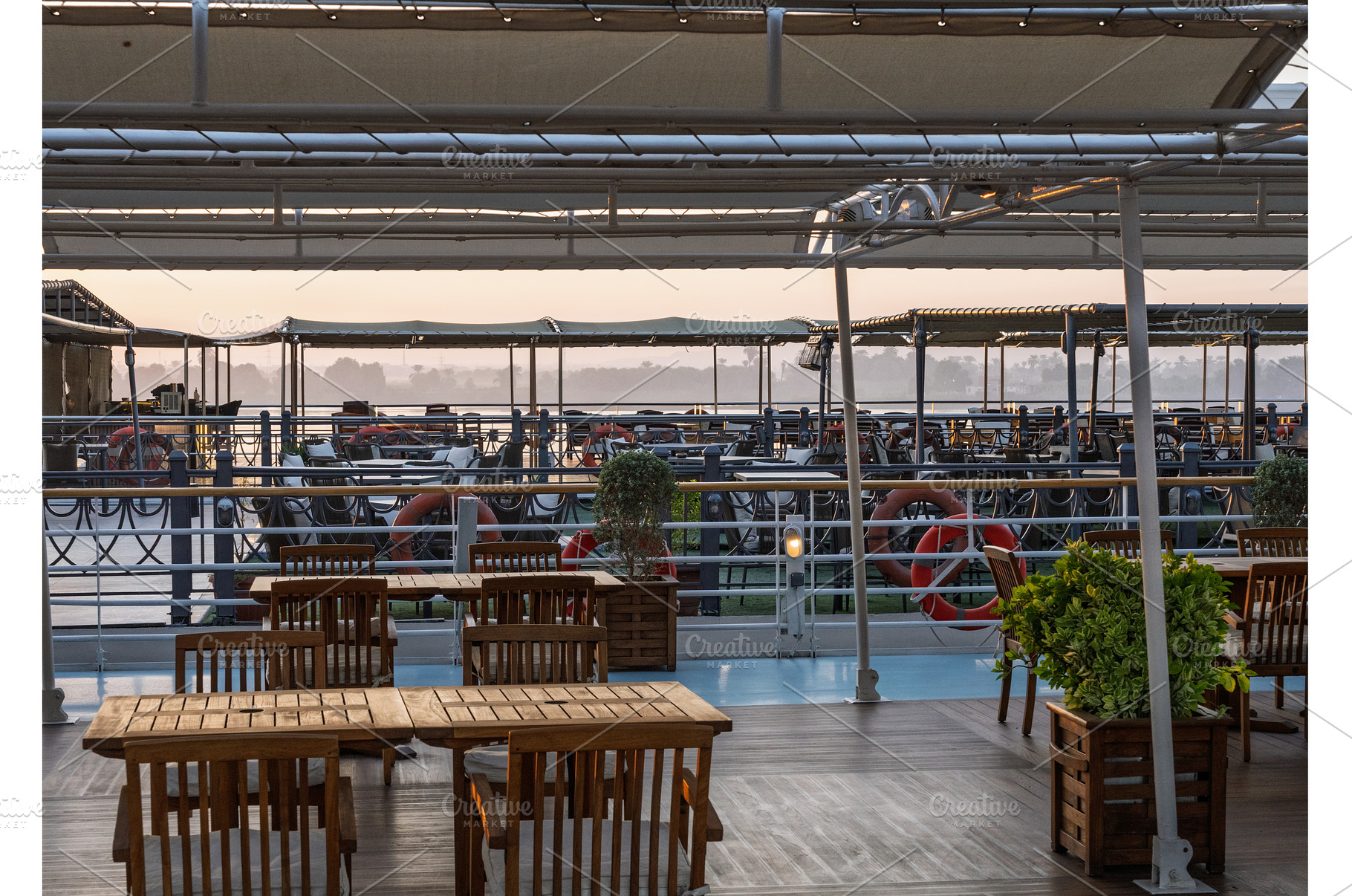 Sun rises over the tables on deck of, a Nature Photo by Backyard Stock