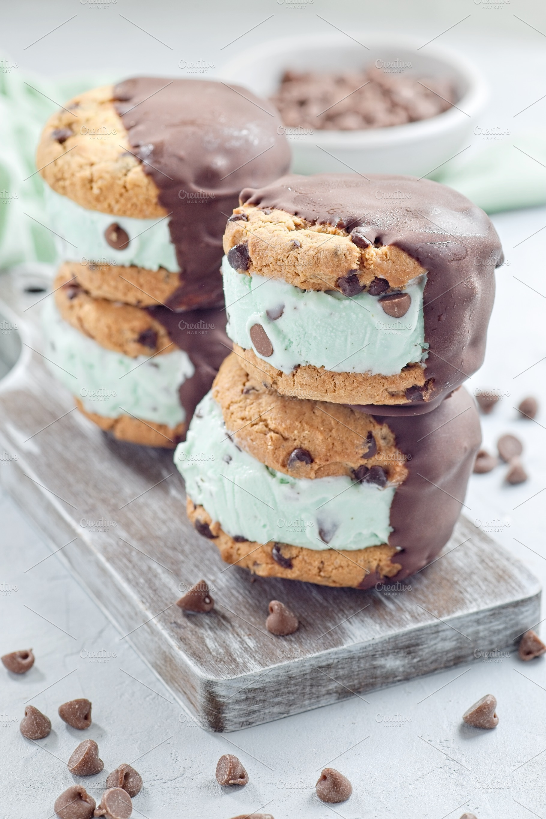 Mint chocolate chips ice cream and chocolate chips cookies sandwiches, on woode, a Food & Drink Photo by iuliia_n