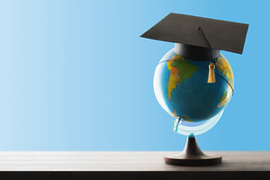 Study abroad concept with globe and mortarboard on wooden table, a School & Education Photo by Davizro's Market