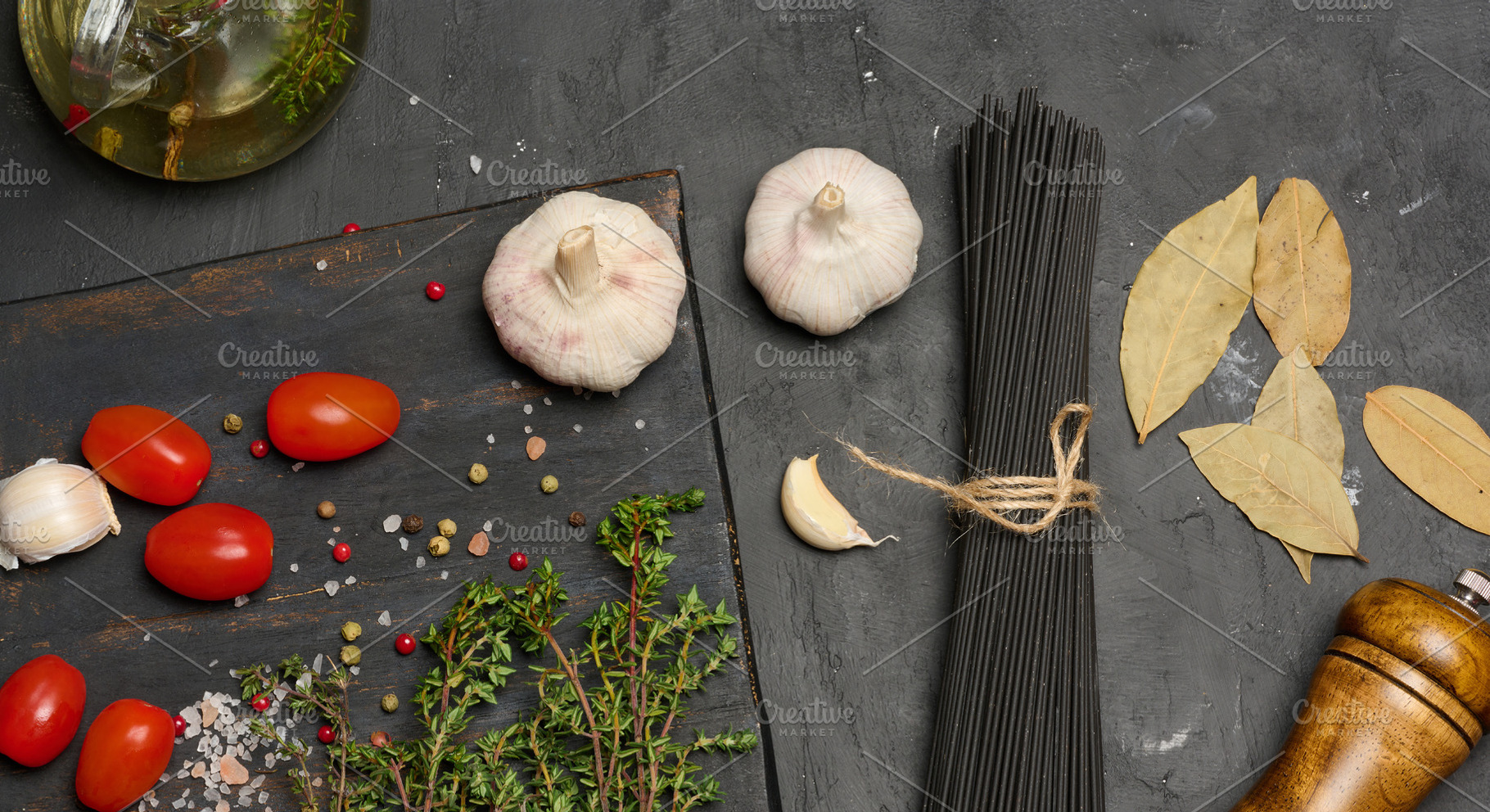 A bunch of black spaghetti, a wooden mill, heads of garlic, a bu, a Food & Drink Photo by ndanko