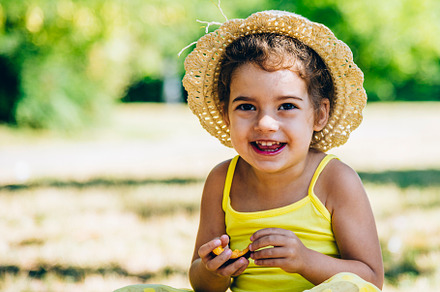 Cute little girl in yellow dress and summer hat enjoy eating fru, a Person Photo by hitdelight