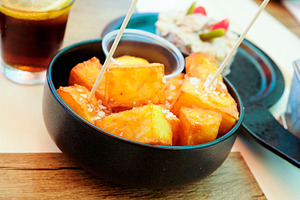 a bowl of spanish patatas bravas on a table, a Photo by Nito