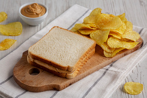 Homemade American Peanut Butter Sandwich and Potato Chips, side, a Food & Drink Photo by LiudmylaChuhunova