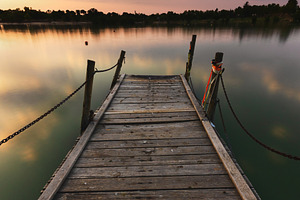 Wooden Pier at Sunset on a Serene La, a Nature Photo by Perpis