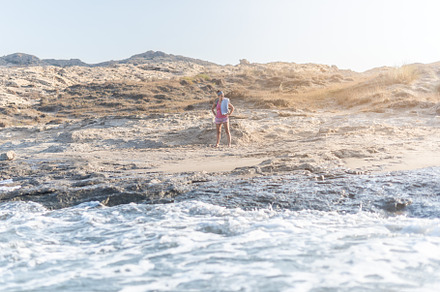 Woman on sandy beach near foamy sea, a Holiday Photo by Iván Moreno STOCK PHOTO