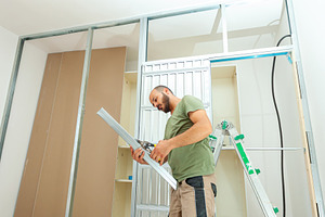 Construction worker building plasterboard wall for a sliding door wardrobe, an Industrial Photo by Antonio Gravante Market