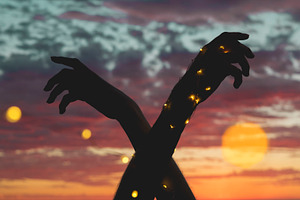 Hands with lights at sunset