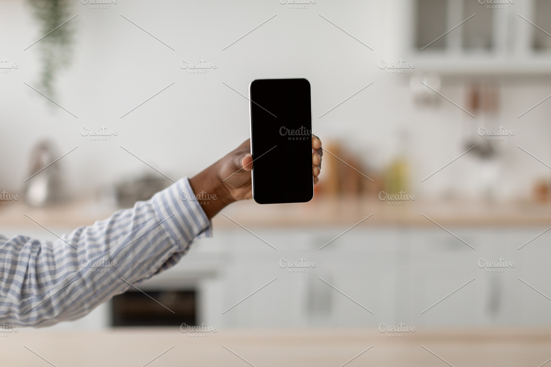Hand of young african american woman show smartphone with blank screen at scand, a Person Photo by Prostock-Studio