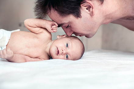 a father kisses his newborn son
