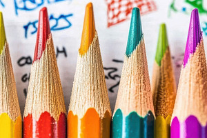 Colorful pencils on child's drawing, a Photo by Pixeness Studio