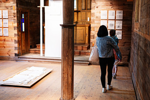 Mother and child exploring a rustic wooden interior with art displays, a Person Photo by AS photostudio