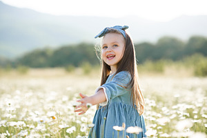 Cute child girl in flowers field