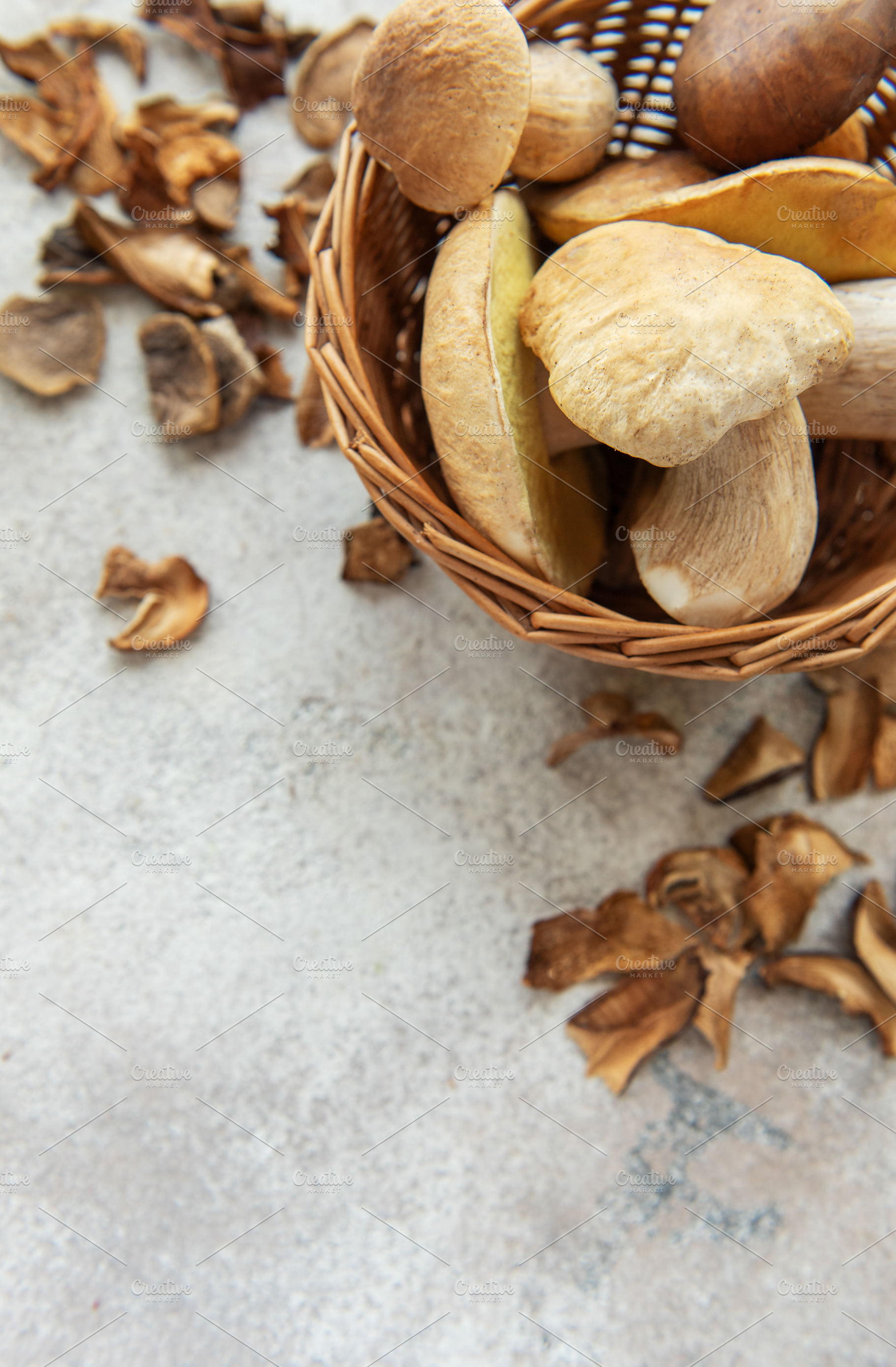 Fresh mushrooms in basket with dried mushrooms on table, a Food & Drink Photo by Olena Rudo