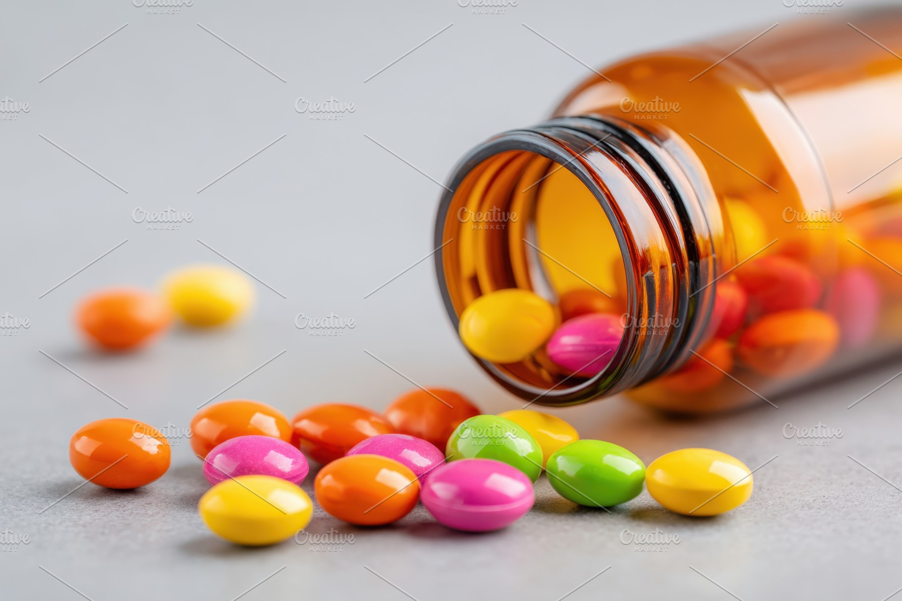 Colorful candies spilling from a glass bottle, a Health & Medical Photo by AlyaAnd