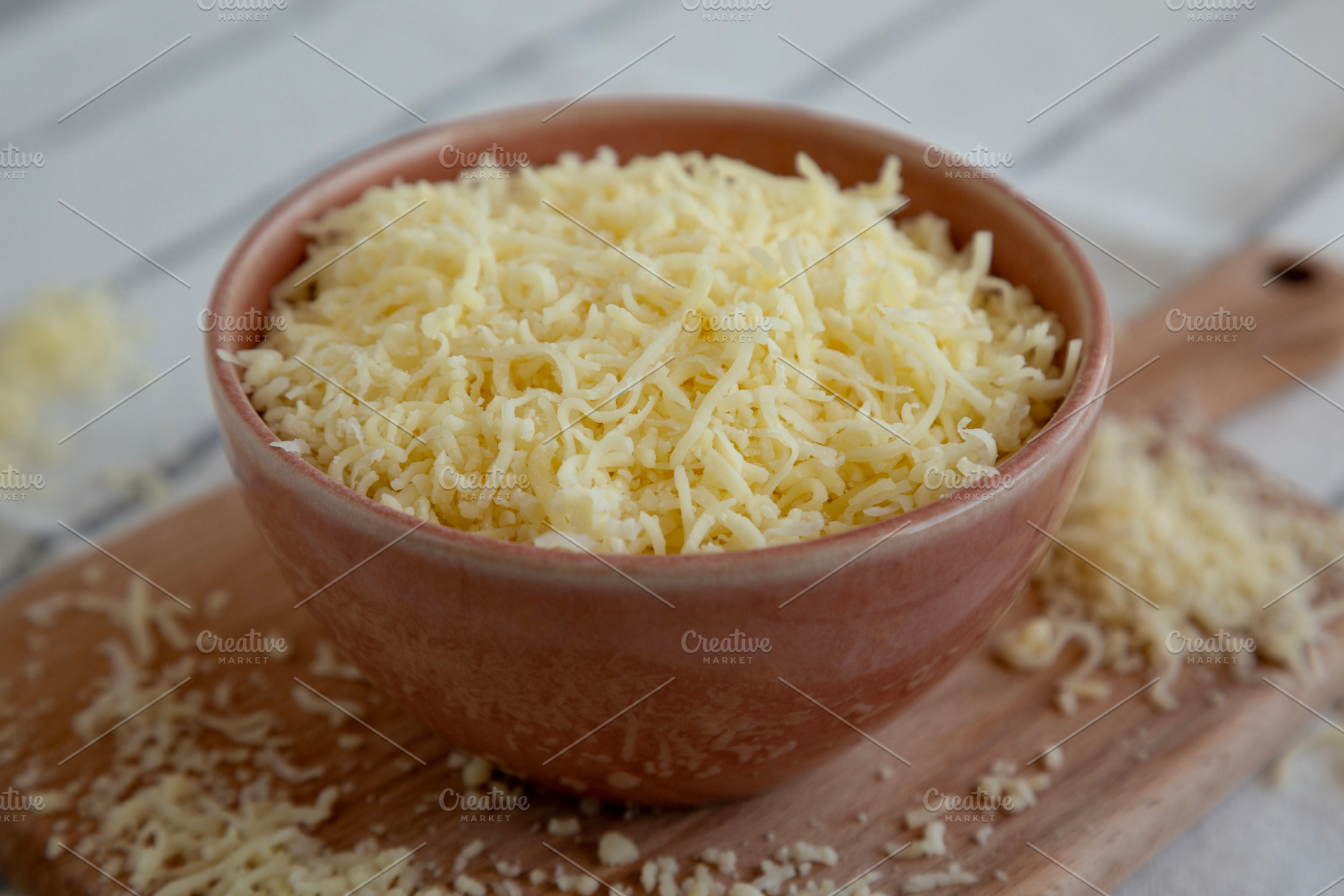 Organic Grated Cheese Mix in a Bowl, side view. Close-up., a Food & Drink Photo by LiudmylaChuhunova