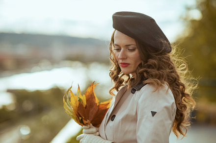 pensive elegant woman in beige trench coat and black beret, a Person Photo by Alliance Images