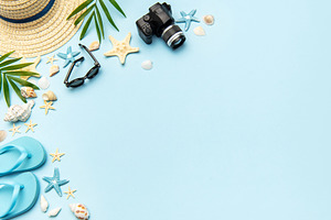 Summer accessories creating frame on light blue background with, a Holiday Photo by Olena Rudo