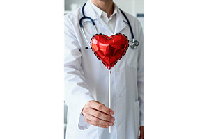 Doctor holding a red heart-shaped, a Health & Medical Photo by tilialucida