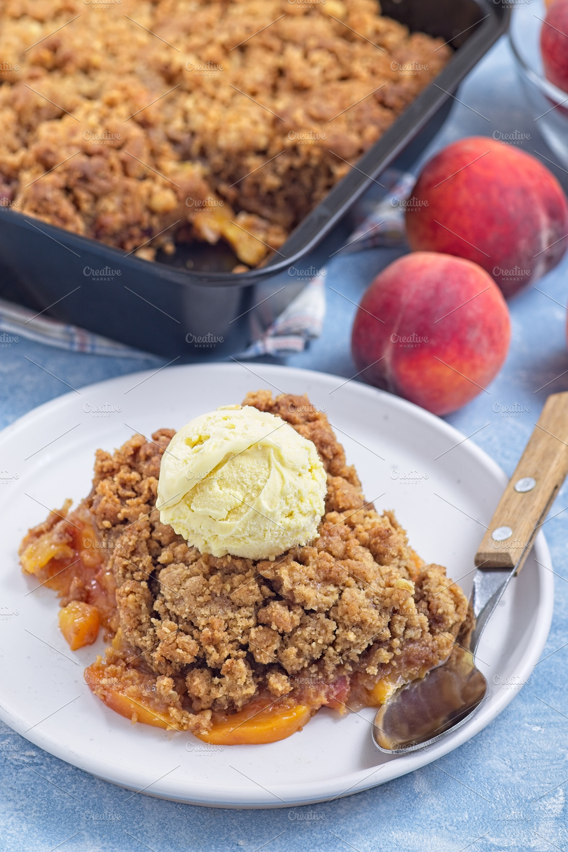 Delicious Peach Crisp or cobbler on plate with scoop of vanilla ice cream, vert, a Food & Drink Photo by iuliia_n