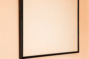 Blank picture frame on peach wall offering copy space for mockups, interior des, a Photo by Studio ANNA