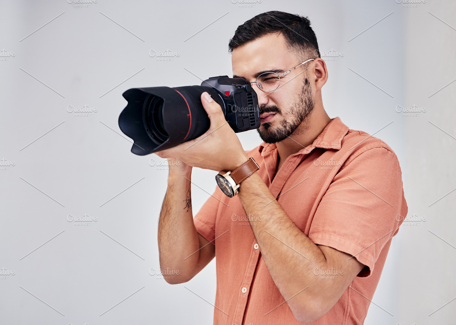 Photographer, camera and art with a man in studio on a gray background for modern or creative photography. Media, production and photoshoot with a male photo professional or artist working backstage, a Photo by Peopleimages.com