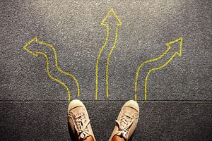 Feet standing among many drawn arrows, symbolizing decision, a Photo by salmon.black