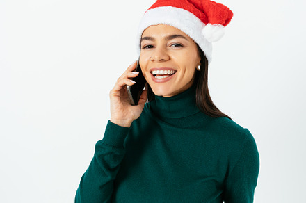 Close up portrait beautiful young woman wearing Santa hat talkin, a Person Photo by progressman
