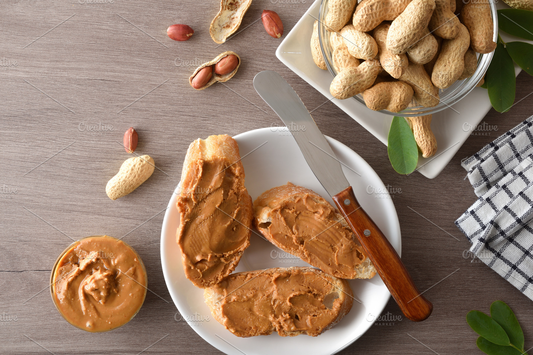 Freshly sliced bread spread with peanut butter on wooden t, a Food & Drink Photo by Davizro's Market