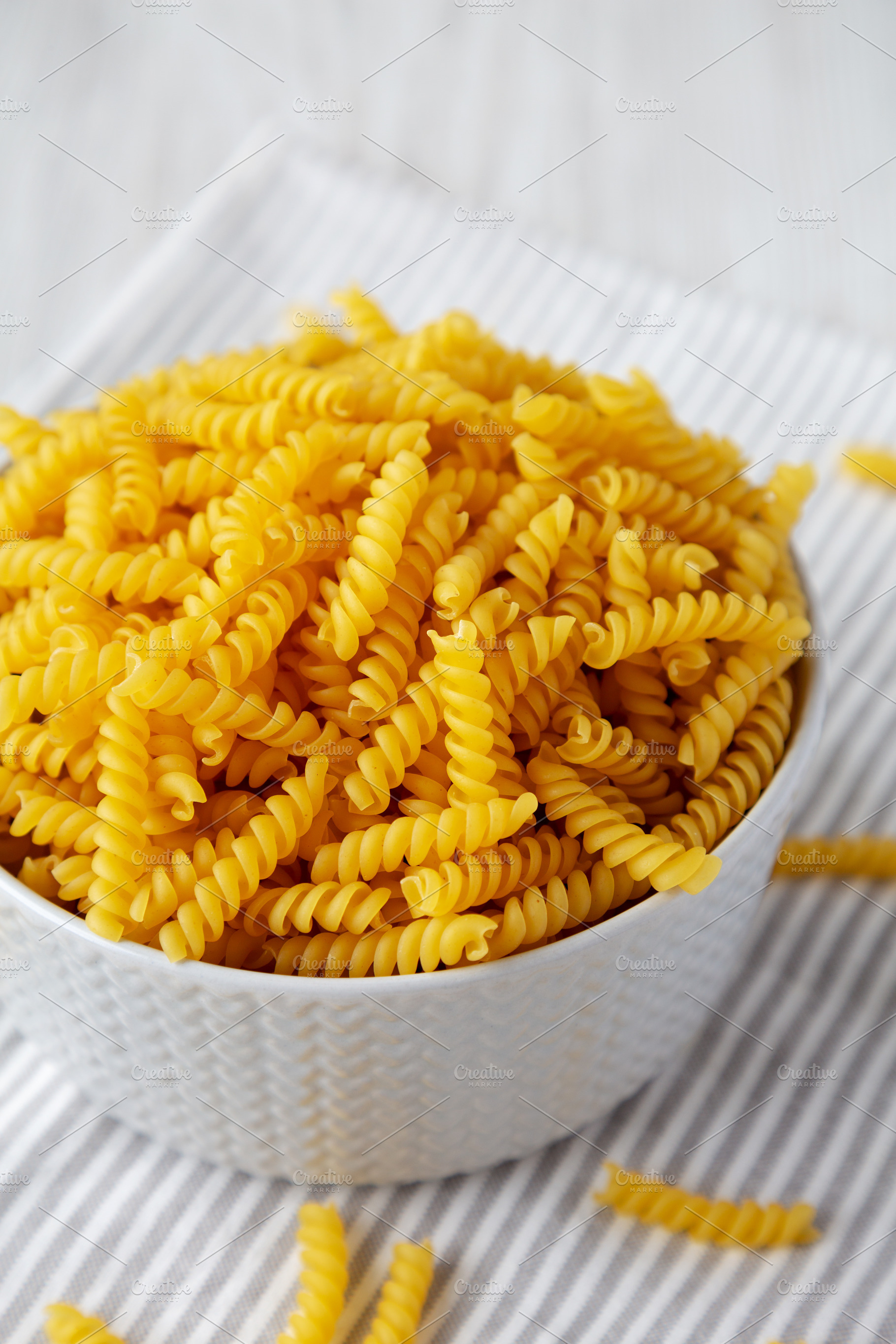 Raw Dry Organic Rotini Pasta Ready to Cook, low angle view. Clos, a Food & Drink Photo by LiudmylaChuhunova