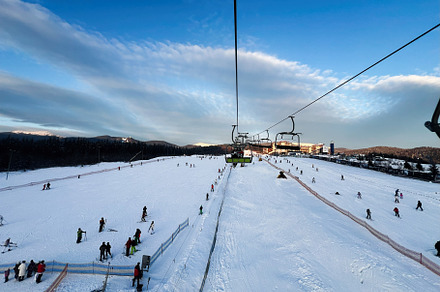 Ski resort with visitors enjoying slopes and surrounding scenic snowy landscape, a Photo by AS photostudio