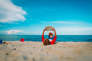 child reading on beach