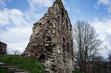 Ancient stone wall ruins under a bright blue cloudy sky in Buchach, Ukraine, a Photo by AS photostudio