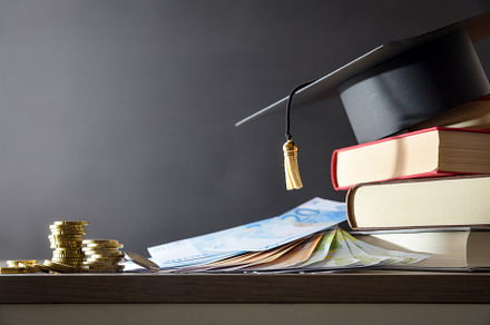 Education spending concept detail with mortarboard books and mon