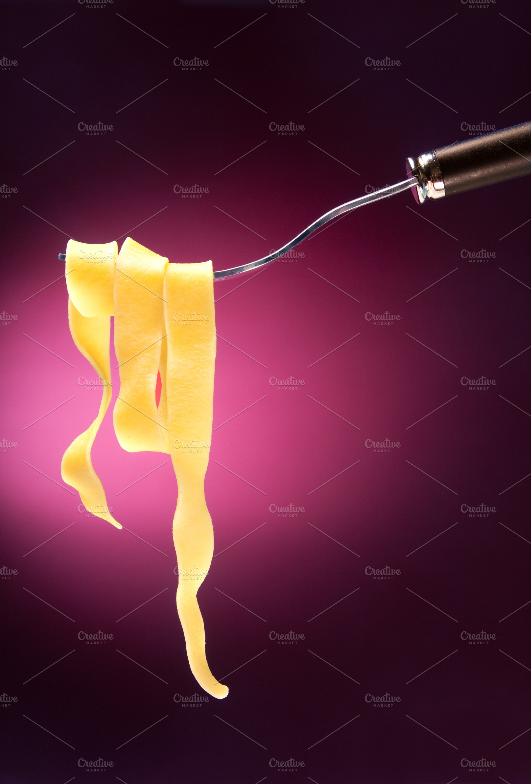 Fork with tagliatelle on a red background, a Food & Drink Photo by FoodStock