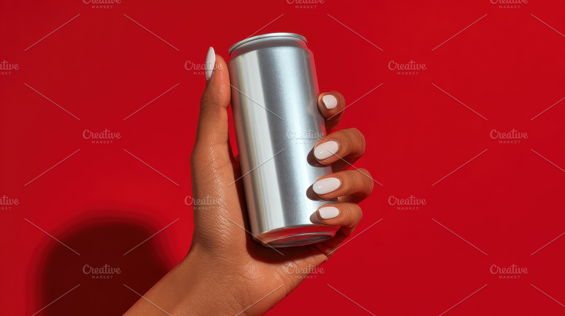 Person holding a silver can on red, a Photo by Beautiful things