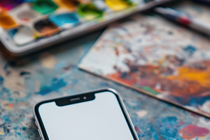 A smartphone iPhone mockup with a blank screen placed on a colorful, paint-spla, an iPhone Mockup by Textures & Backgrounds