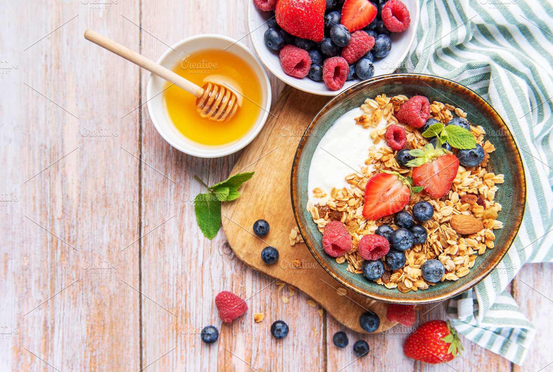 Healthy breakfast granola with fresh berries and honey, a Food & Drink Photo by Olena Rudo