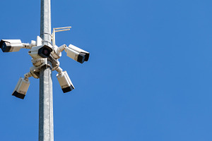 Multiple security cameras mounted on a pole against clear blue sky, symbolizing, an Industrial Photo by Ales Munt
